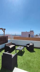 eine Terrasse mit Sofas und einem Tisch auf dem Dach in der Unterkunft Puipana Apartment, Fuerteventura in Puerto del Rosario