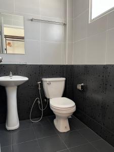 La salle de bains est pourvue de toilettes et d'un lavabo. dans l'établissement Ivory House Sriracha, à Si Racha