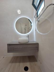 a bathroom with a sink and a mirror at The Passion Fruit House in São Vicente