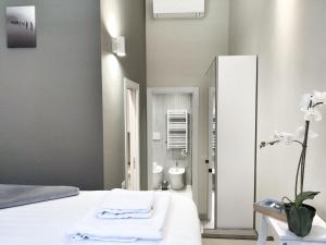 sypialnia z białym łóżkiem i lustrem w obiekcie Luxury Apartament - Graziano 39 - 2 w Mediolanie