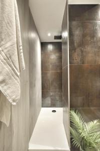 a bathroom with a walk in shower next to a wall at Luxury Apartament - Graziano 39 - 2 in Milan