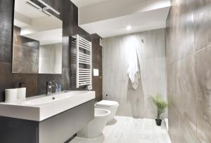 łazienka z białą umywalką i toaletą w obiekcie Luxury Apartament - Graziano 39 - 2 w Mediolanie