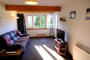 a living room with a couch and a television at Lovely 1-bedroom apartment with free parking in Inverness