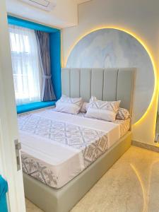 a bedroom with a large bed with a large headboard at Apartment Podomoro Medan in Medan