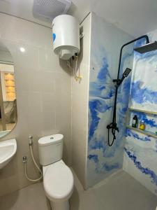 ein Badezimmer mit einem weißen WC und einem Waschbecken in der Unterkunft Apartment Podomoro Medan in Medan
