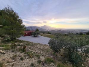 a house sitting on top of a hill with the sunset at Cabañas by Torre de Arriba in Benimantell