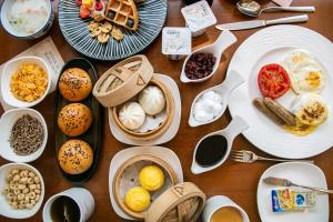 a wooden table topped with plates and bowls of food at Crowne Plaza Beijing International Airport, an IHG Hotel in Shunyi