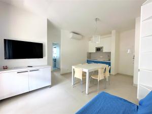 a kitchen and dining room with a table and a tv at Residence Acapulco in Bibione