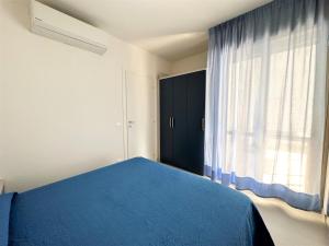 a bedroom with a blue bed and a window at Residence Acapulco in Bibione +10 photos