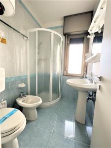 a bathroom with a shower and a toilet and a sink at Residence Acapulco in Bibione