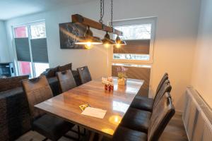 een eetkamer met een houten tafel en stoelen bij Harznester - Dein Nest am See in Thale