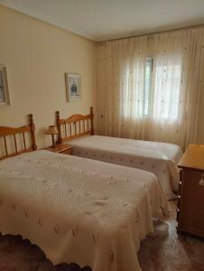 1 dormitorio con 2 camas y ventana en Nuosavas namas, en Lo Pagán