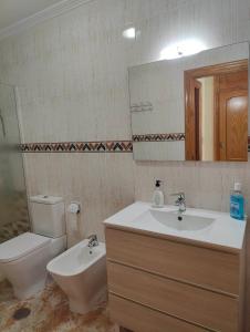 y baño con lavabo, aseo y espejo. en Nuosavas namas, en Lo Pagán