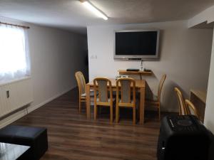 a dining room with a table and chairs and a television at Apartmán u Moniky 