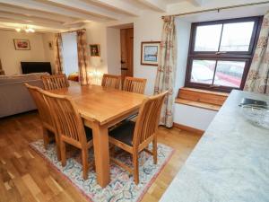 a dining room with a wooden table and chairs at Iris Cottage in Penzance