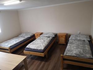 a group of three beds in a room at Apartmán u Moniky 