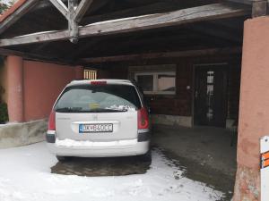 un coche blanco aparcado en un garaje en la nieve en Apartmán u Moniky 