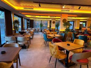 ein Restaurant mit Tischen und Stühlen in einem Raum in der Unterkunft Milmari Apartments - N Lux 108 - SPA OPENING DECEMBER 2025 in Kopaonik