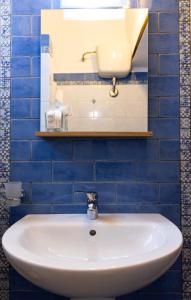 a white sink in a blue tiled bathroom at L'Aurora Scala Dei Turchi in Realmonte