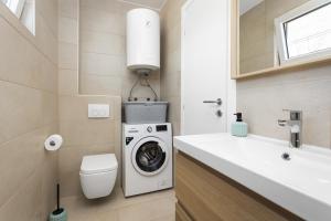 une salle de bain avec une machine à laver et un lavabo dans l'établissement Villa Angie with Heated Pool, à Vodnjan