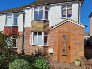 a brick house with a brown door in front of it at Peaceful retreat / spacious bedroom / free parking in Brighton & Hove