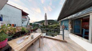 een balkon met een houten bank en een parasol bij Antigoni Apartments in Parga