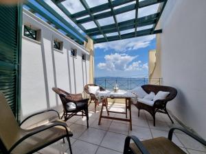 a patio with a table and chairs on a balcony at Cosy apartment by the sea in Nea Potidaea