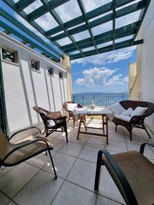 a patio with chairs and a table on a balcony at Cosy apartment by the sea in Nea Potidaea