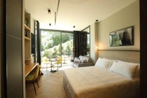 Un dormitorio con una cama y un escritorio en una habitación. en Villa Carla Suites in Barolo, en Barolo