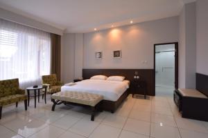 um quarto com uma cama, uma mesa e cadeiras em Hotel Sindha em Ruteng