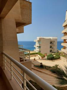 a view of the ocean from the balcony of a building at Castel Mare Beach Hotel & Resort in Jbeil