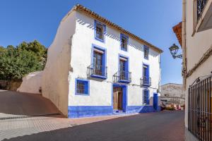un edificio azul y blanco al lado de una calle en Casa Rural La Clau, en Polop