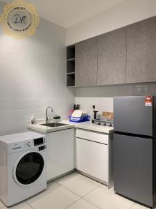 una cucina con lavatrice e lavatrice di Arte MontKiara Cozy n Spacious 1BR 100mbps_Jacuzzi a Kuala Lumpur
