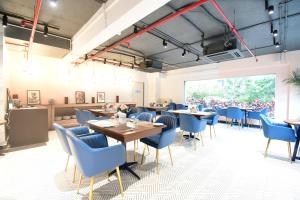 uma sala de jantar com mesas e cadeiras azuis em The Xen Suites, Kolkata Airport em Calcutá