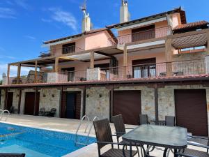 a villa with a swimming pool and a house at Captain's apartments in Pefkochori