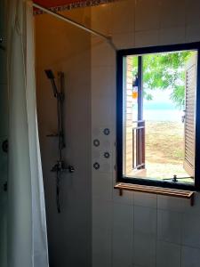 a bathroom with a shower with a window at Beach House Penida in Nusa Penida