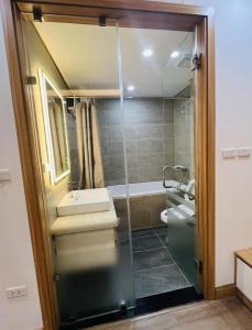uma casa de banho com uma cabina de duche em vidro com um lavatório e uma banheira em H&A Homestay - 40m, New Built, Center Location, Quiet Place, Full Facilities em Hanói
