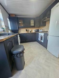 a kitchen with blue cabinets and a white refrigerator at Spacious Swanky Home 4 Groups & Contractors near NEC & Airport in Olton