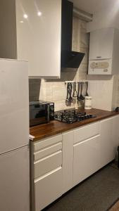 a kitchen with white cabinets and a stove top oven at Evanelly lodge in Gillingham