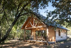 una pequeña cabaña de madera con techo de gambrel en Village Huttopia Sud Ardèche en Vagnas