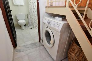 a washing machine in a bathroom with a toilet at Villa Kavalino in Kolimbia