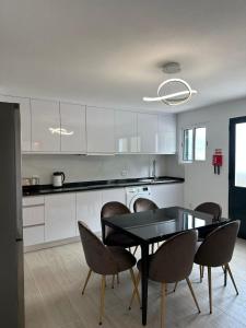 a kitchen with a dining room table and chairs at The Passion Fruit House in São Vicente