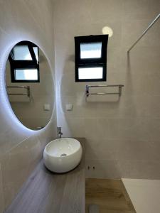 uma casa de banho com um lavatório branco e um espelho. em The Passion Fruit House em São Vicente