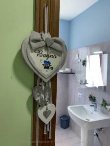 een badkamer met een hartvormig bord naast een wastafel bij La Cascina delle Viole in Norcia