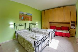 2 Betten in einem Zimmer mit grünen Wänden in der Unterkunft La Cascina delle Viole in Norcia