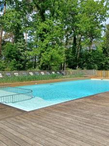 a swimming pool on a wooden deck at Huttopia Rambouillet in Rambouillet