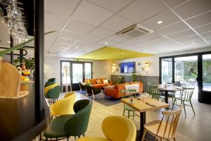 een restaurant met tafels en stoelen en een bank bij Campanile Orange A7/ A9 in Orange