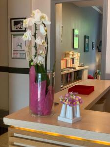 un vaso con fiori bianchi seduto su un tavolo di Hotel Mirabeau a Tours