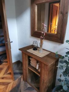 a small wooden table with a vase of flowers on it at Apartma Kačwa in Kobarid