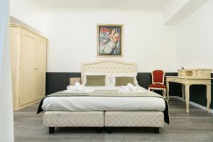 a bedroom with a large bed and a desk at Capitolium Rooms in Rome